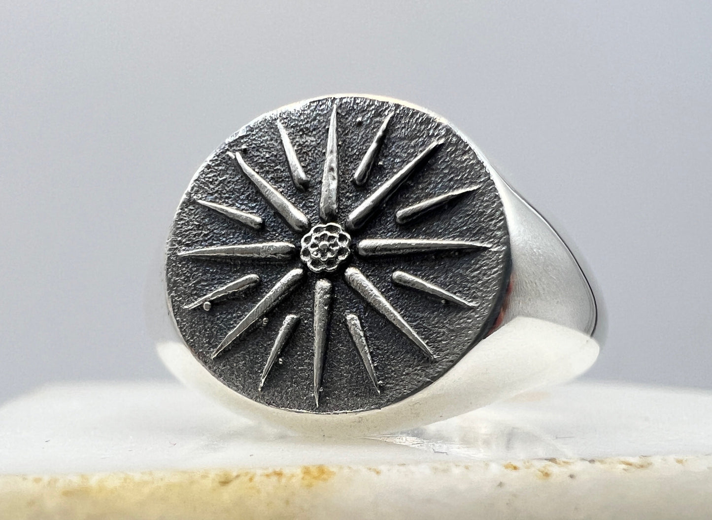Silver ring with a star design on a stone surface